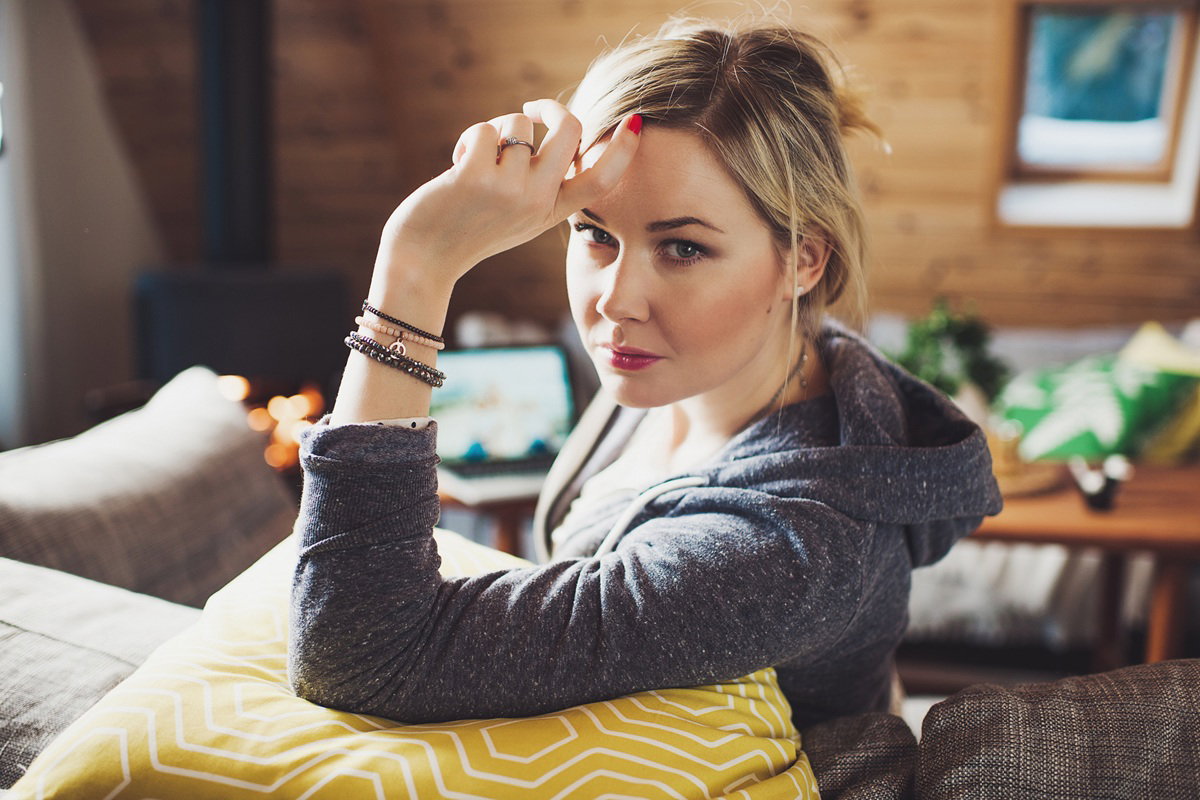 kobieta w wieku 30 plus blondynka siedzi na kanapie zamyślona