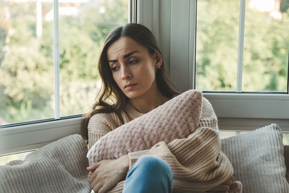 kobieta zmartwiona przy oknie