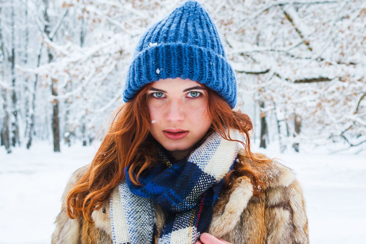 Poważna młoda kobieta w lesie zimą