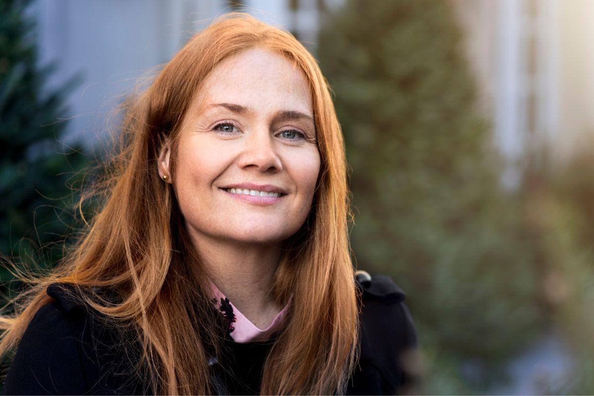 uśmiechnięta kobieta na tle choinek