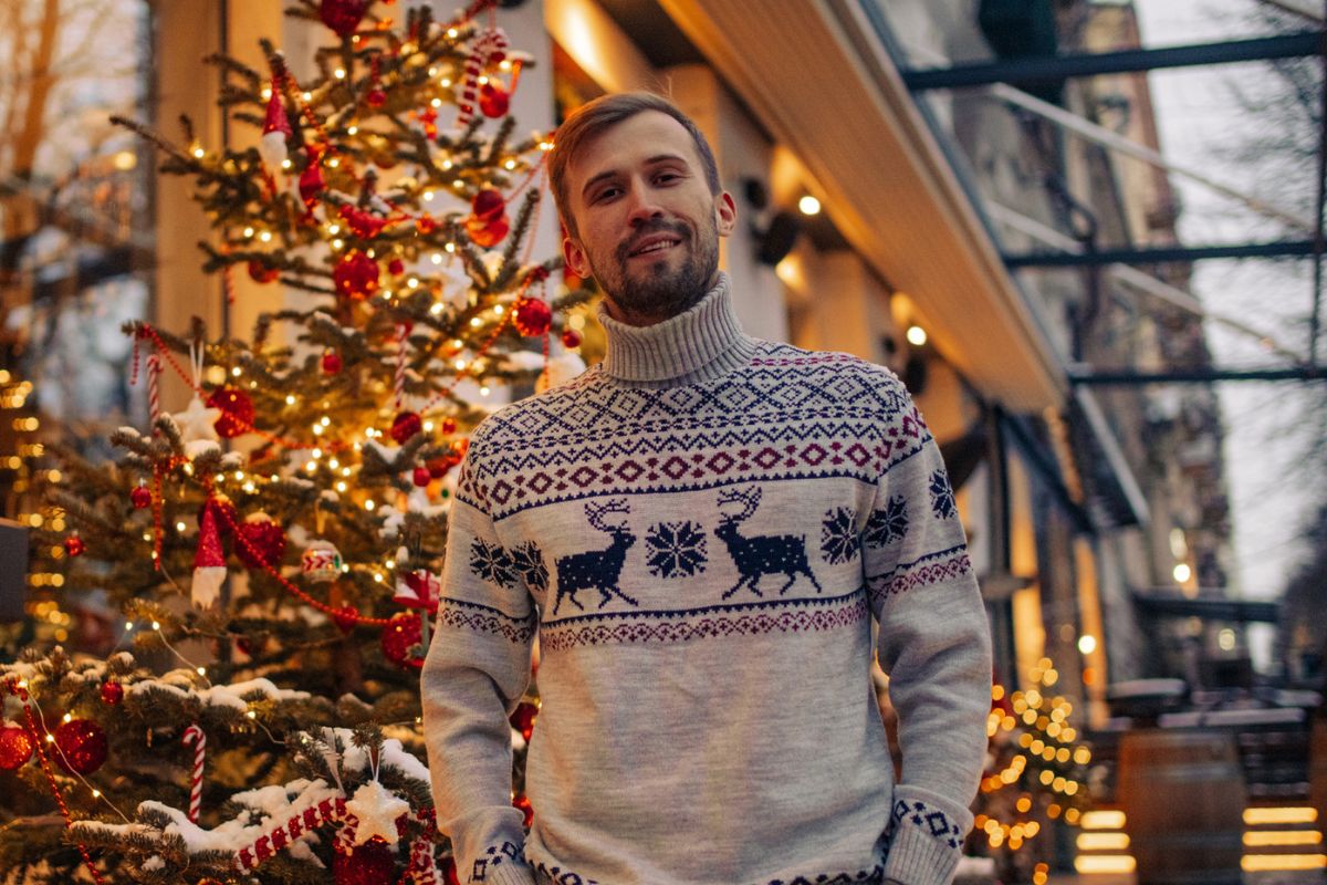 młody chłopak na tle choinki