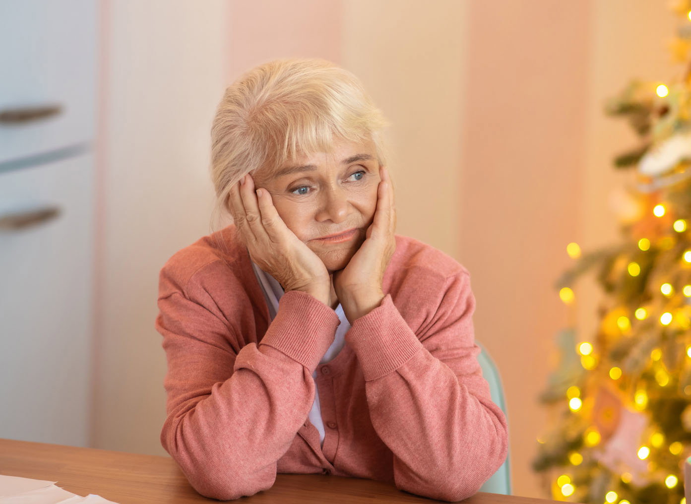 Senior woman sitting at the table and thinking