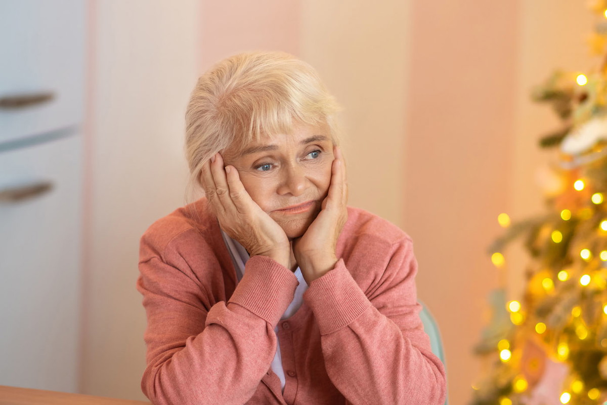 Senior woman sitting at the table and thinking