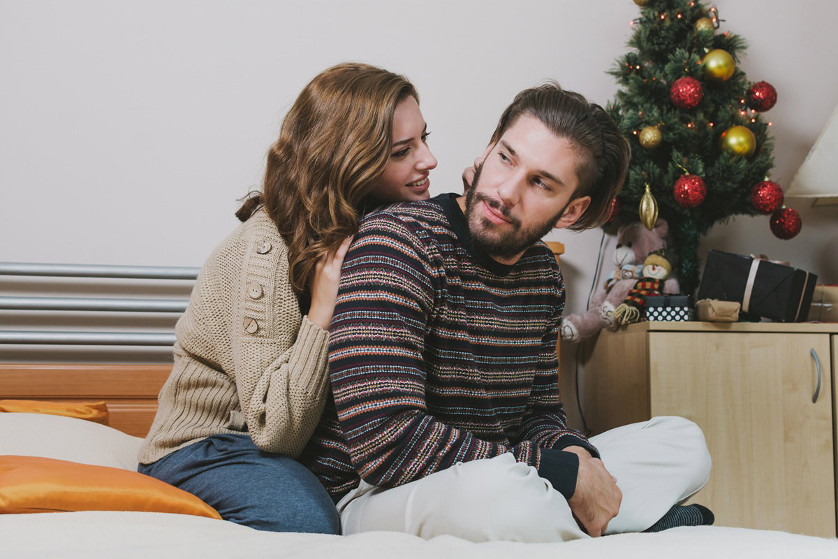 para w wieku około 30 plus siedzi blisko siebie obok choinka