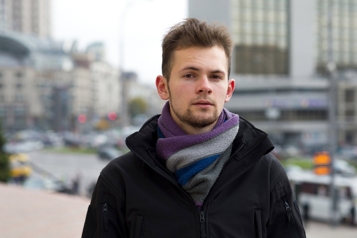 mężczyzna w wieku 30 plus z szalikiem stoi na tle miasta smutny