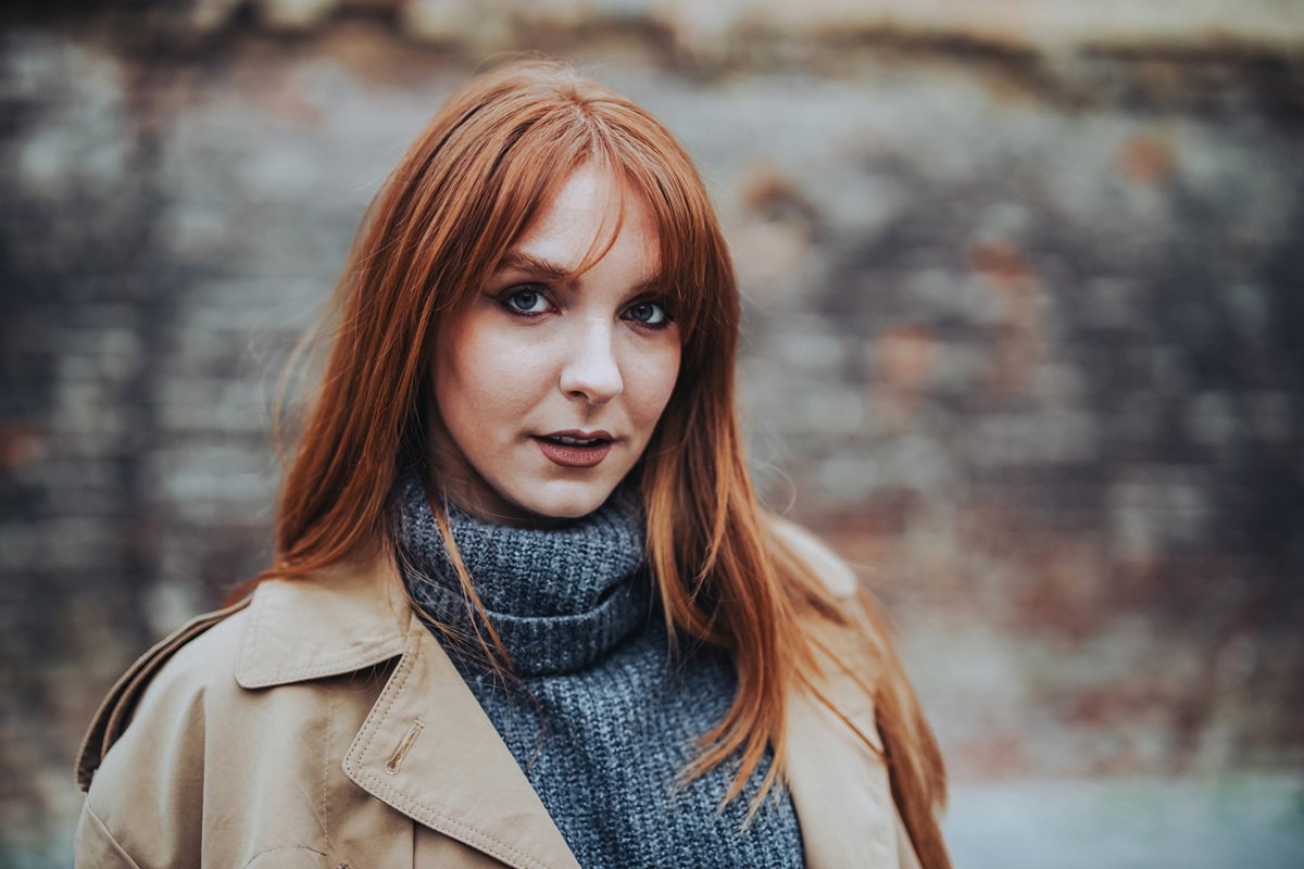 kobieta rude włosy z grzywką w wieku 40 lat około stoi na zewnątrz zamyślona