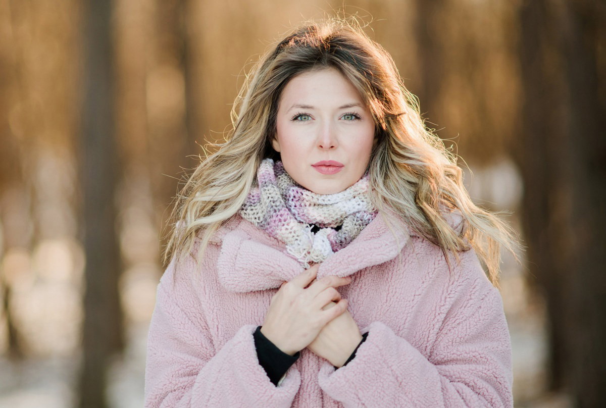 kobieta w wieku 35 plus blondynka w różowej kurtce misiu stoi na zewnątrz zamyślona