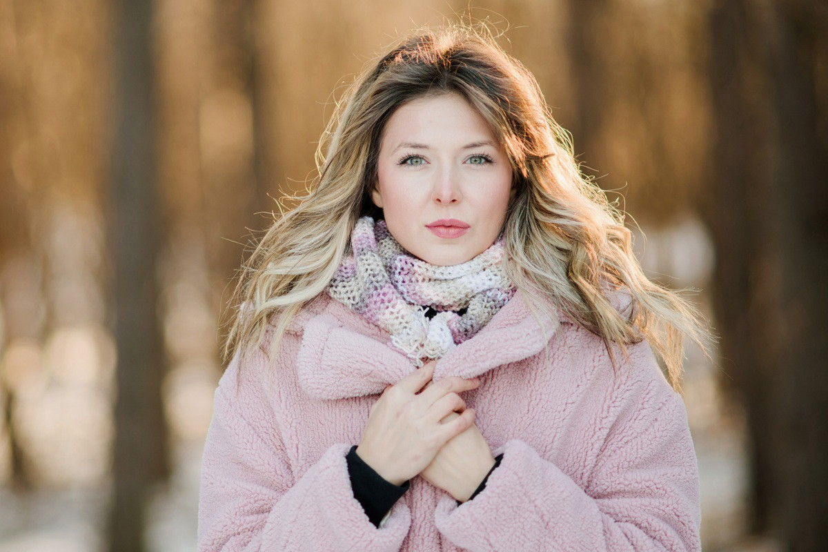 kobieta w wieku 35 plus blondynka w różowej kurtce misiu stoi na zewnątrz zamyślona