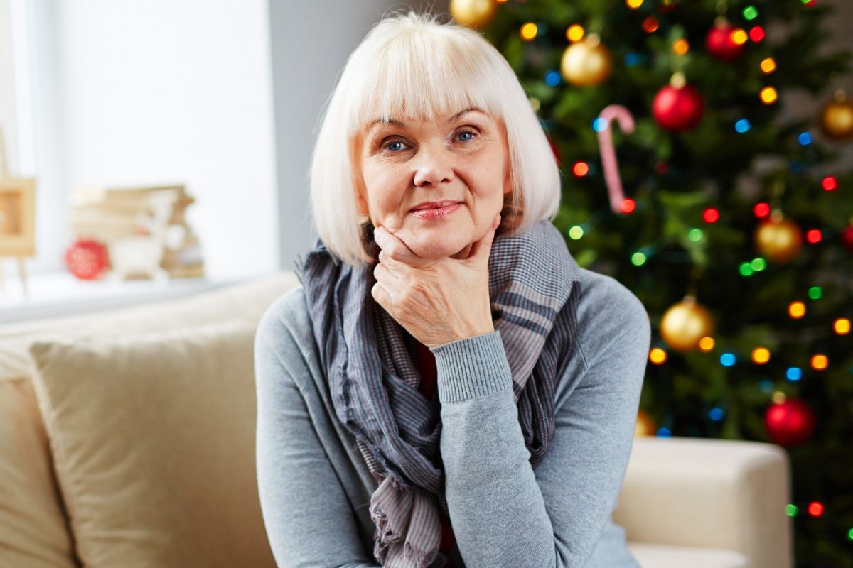 starsza pani na kanapie obok choinki