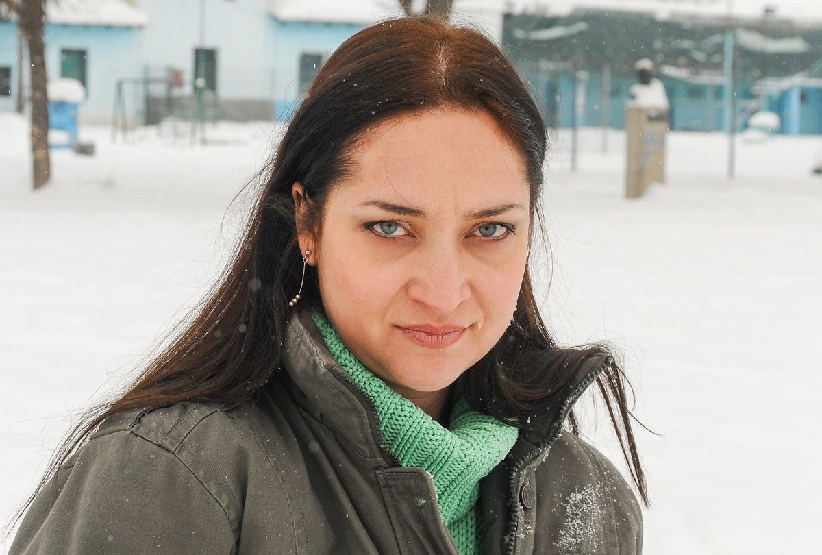 kobieta w wieku 30 plus w zielonej kurtce i swetrze stoi na zewnątrz na śniegu wkurzona