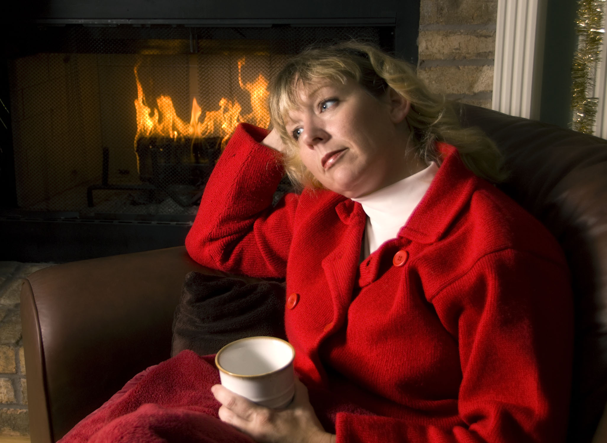 Thoughtful woman by the Fireplace at Christmas