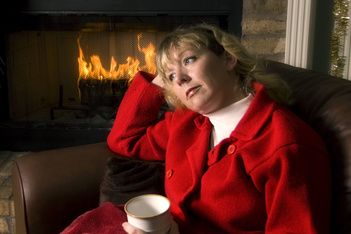 Thoughtful woman by the Fireplace at Christmas