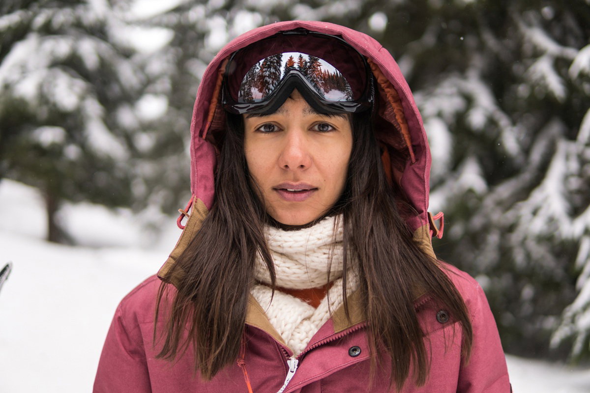 kobieta w wieku 30 plus z goglami na czole stoi zmartwiona na tle zaśnieżonego pejzażu