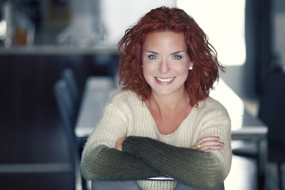 kobieta w wieku 35 plus siedzi na krześle zadowolona i się uśmiecha