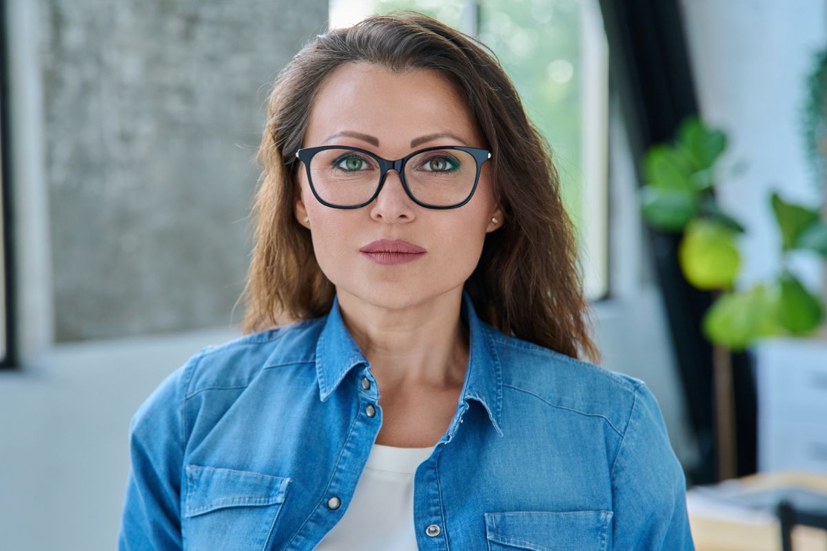 kobieta w niebieskiej koszuli i okularach
