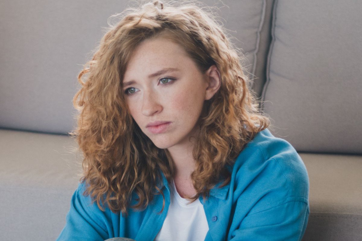 zamyślona kobieta w kręconych włosach