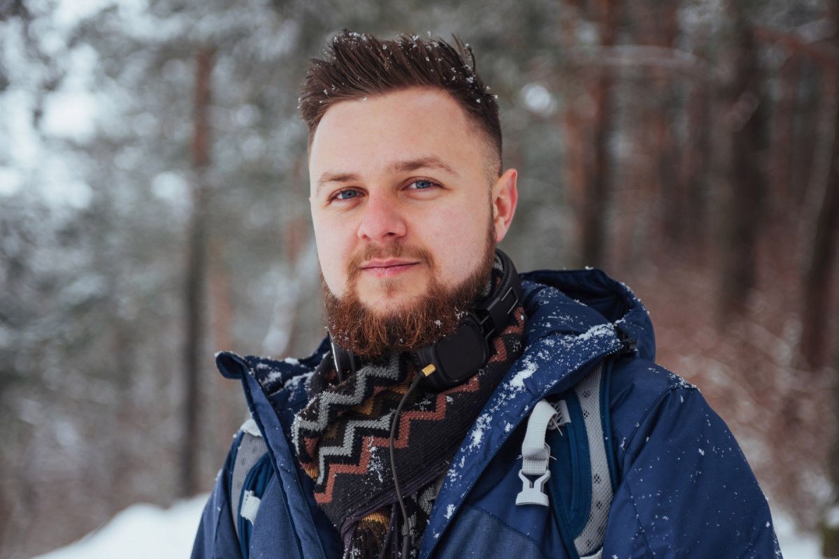 facet na tle lasu zimą