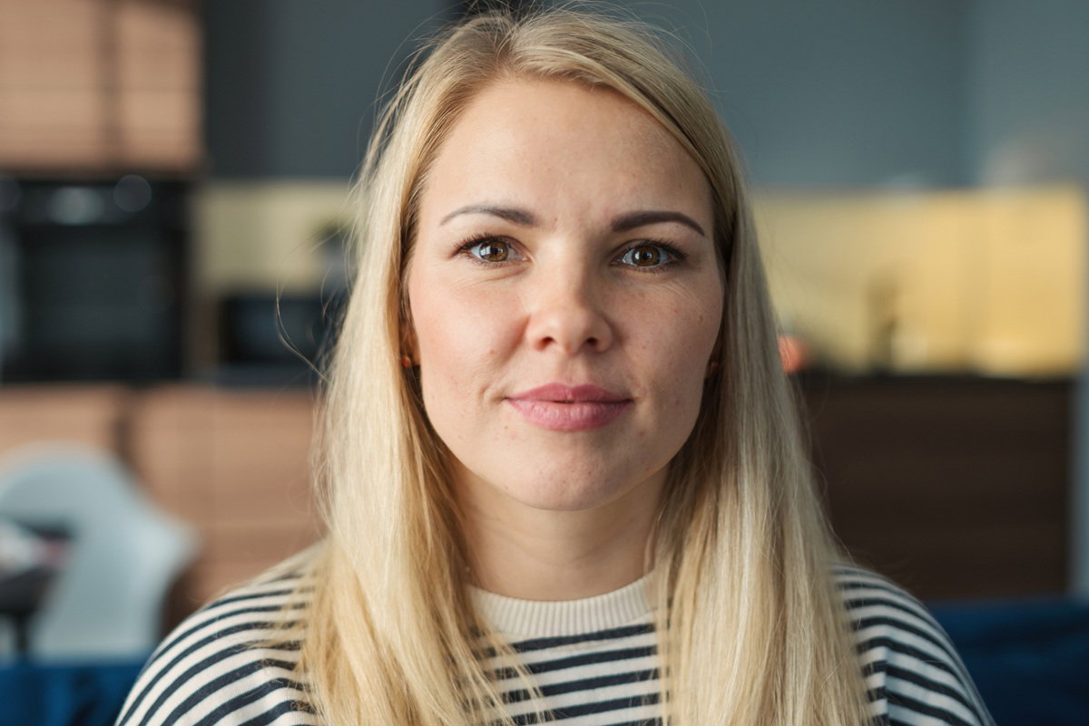 kobieta w wieku 35 plus blondynka stoi w kuchni z zawadiacką miną