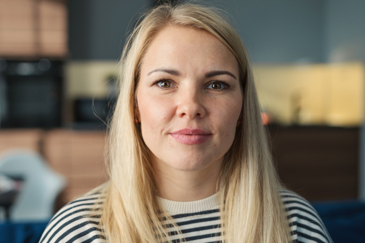 kobieta w wieku 35 plus blondynka stoi w kuchni z zawadiacką miną