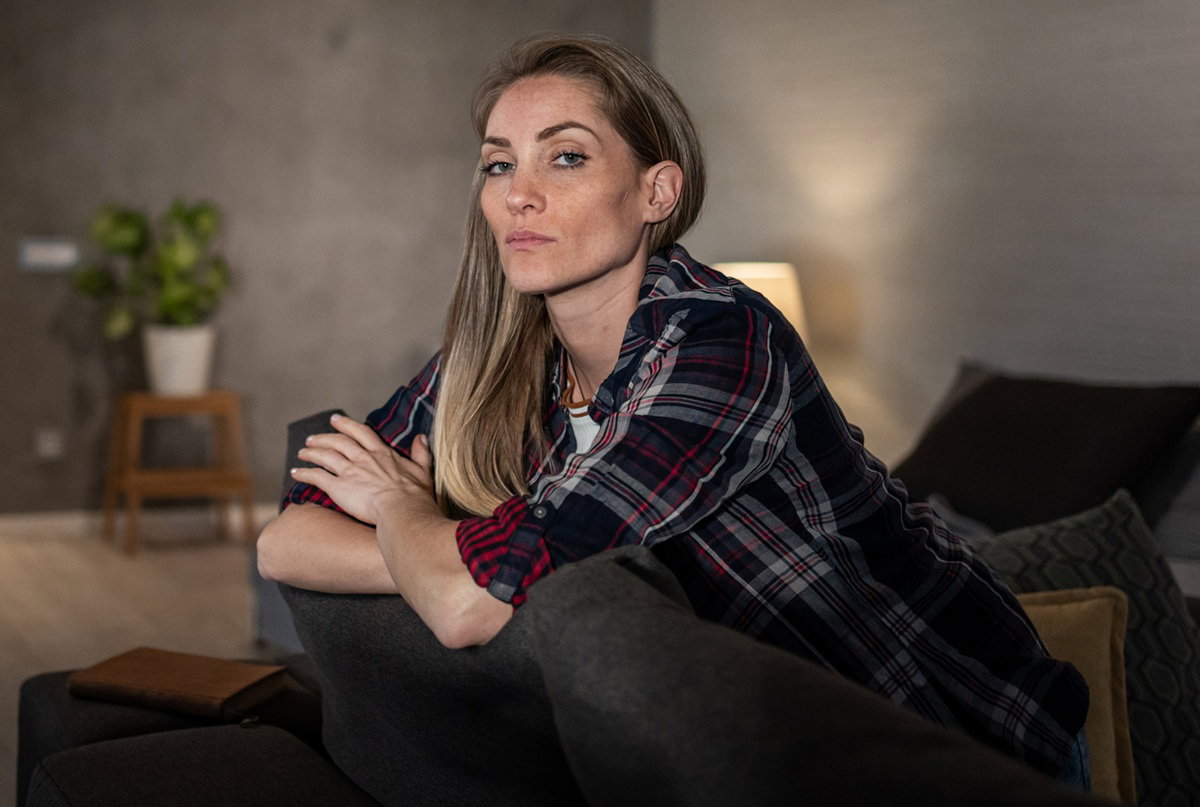 kobieta w wieku 35 plus blondynka z długimi włosami siedzi na kanapie smutna i zła i rozczarowana