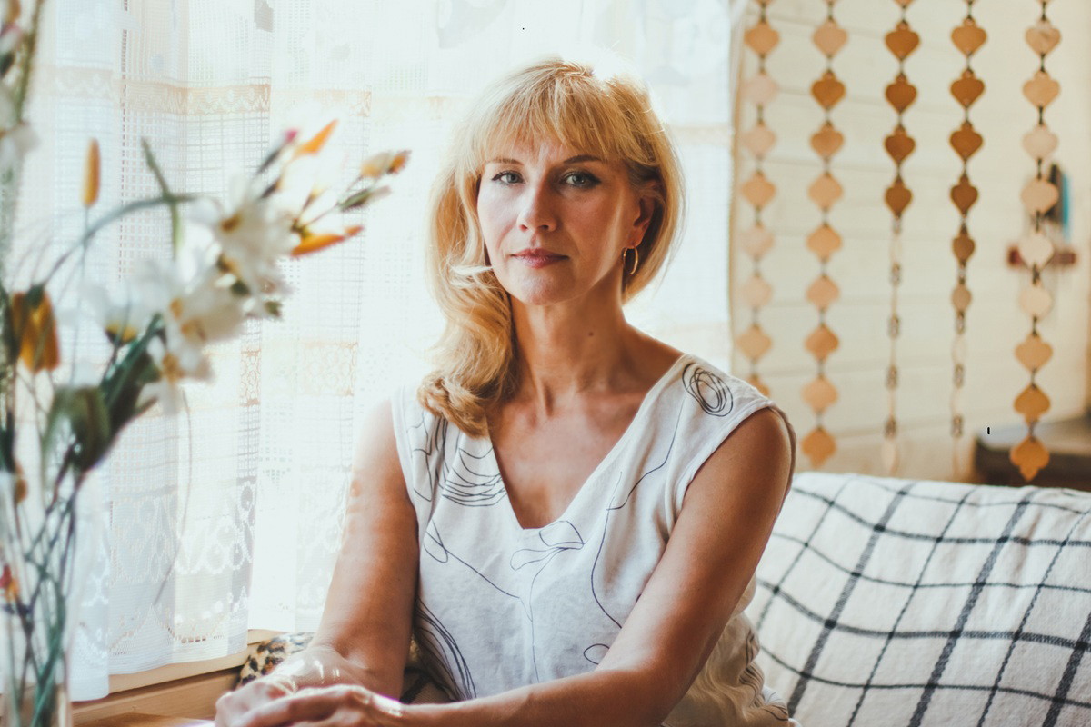 kobieta w wieku 40 plus blondynka siedzi z rękami na stole poważna