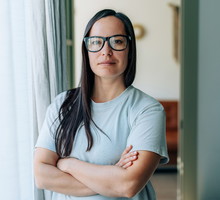 kobieta w wieku 30 plus w okularach stoi poważna ze skrzyżowanymi ramionami