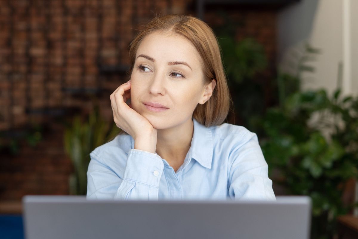 zamyślona kobieta przy laptopie