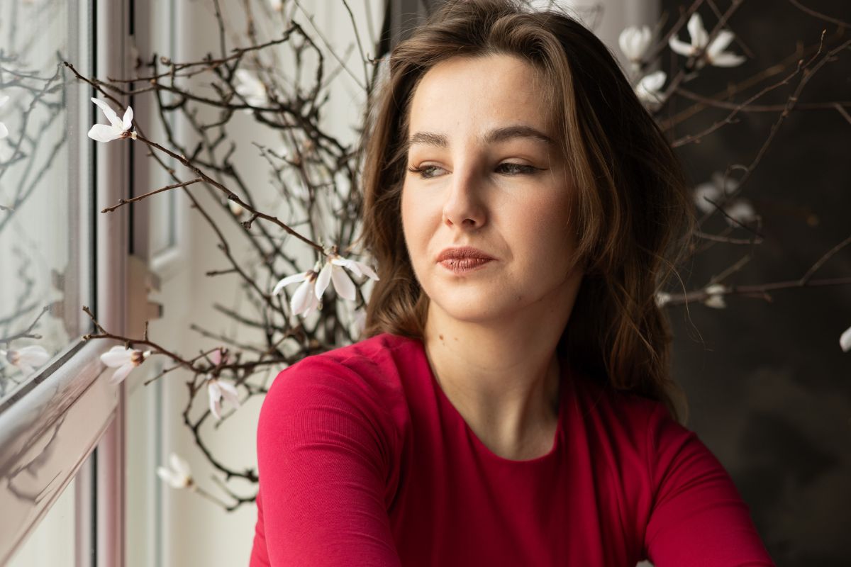 Zamyślona kobieta przy oknie