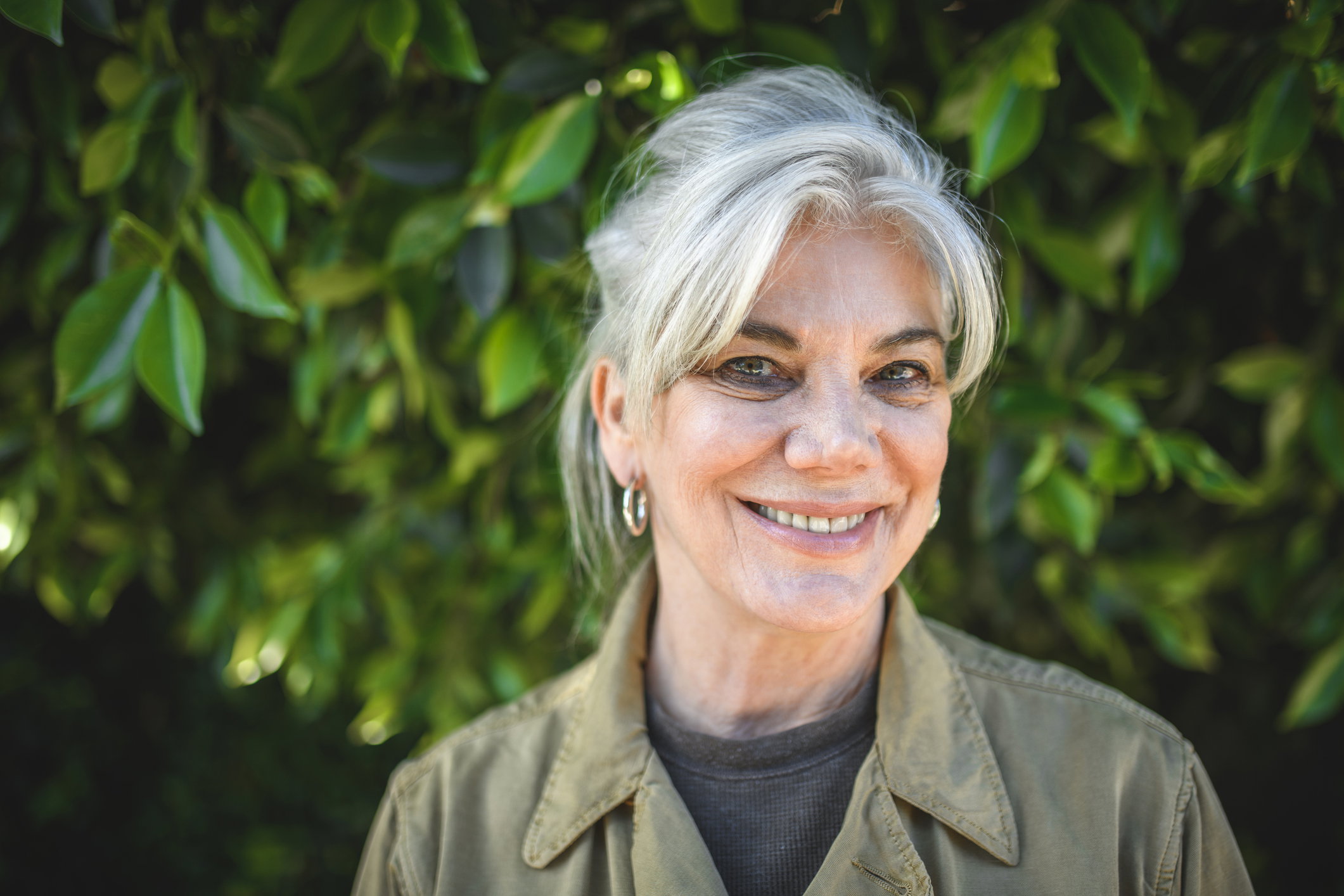 Portrait of senior woman smiling against plants
