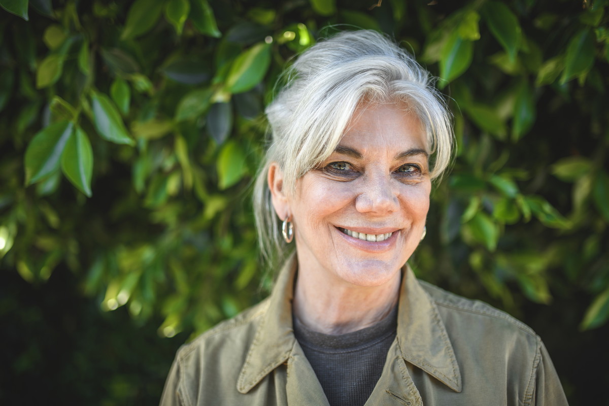Portrait of senior woman smiling against plants