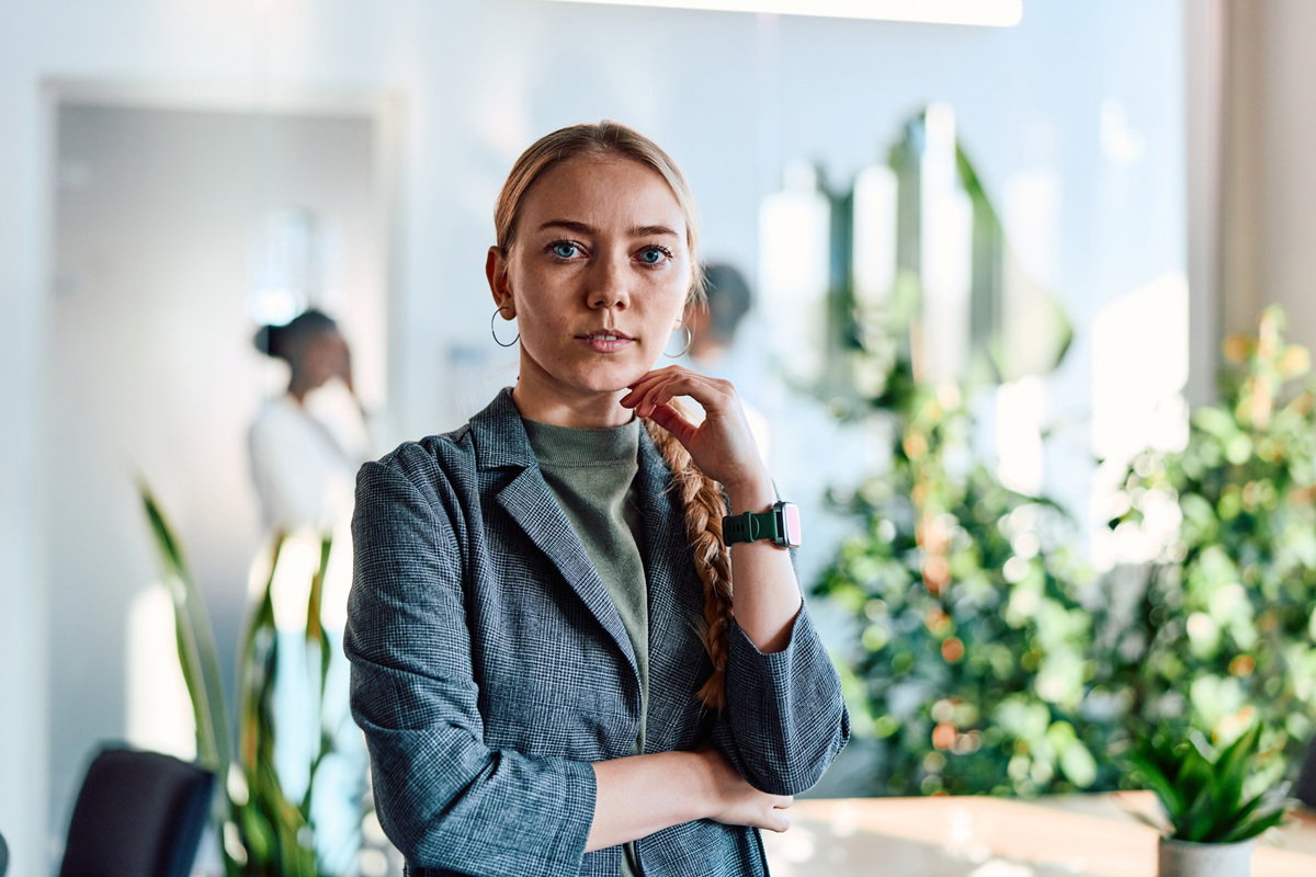 kobieta w wieku około 30 lat blondynka stoi w biurze na tle roślin
