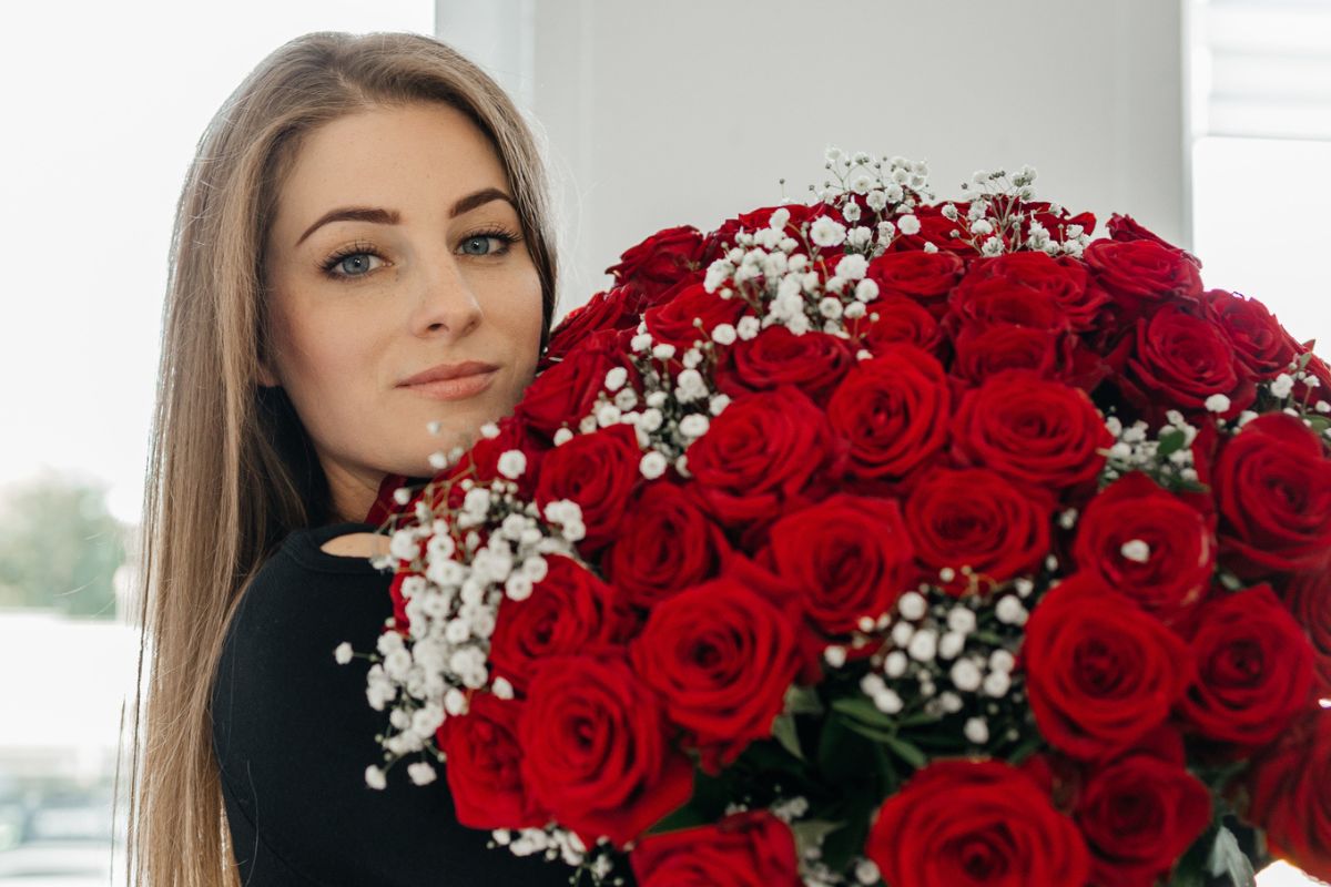 kobieta z dużym bukietem róż