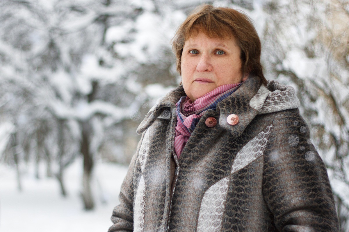 kobieta w wieku 60 plus na tle zimowego pejzażu stoi smutna i zmartwiona
