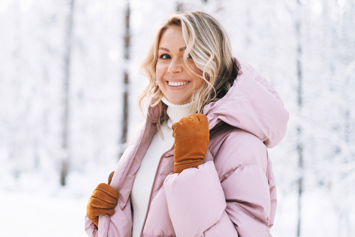 kobieta w wieku 30 plus w różowej kurtce blondynka uśmiecha się zadowolona