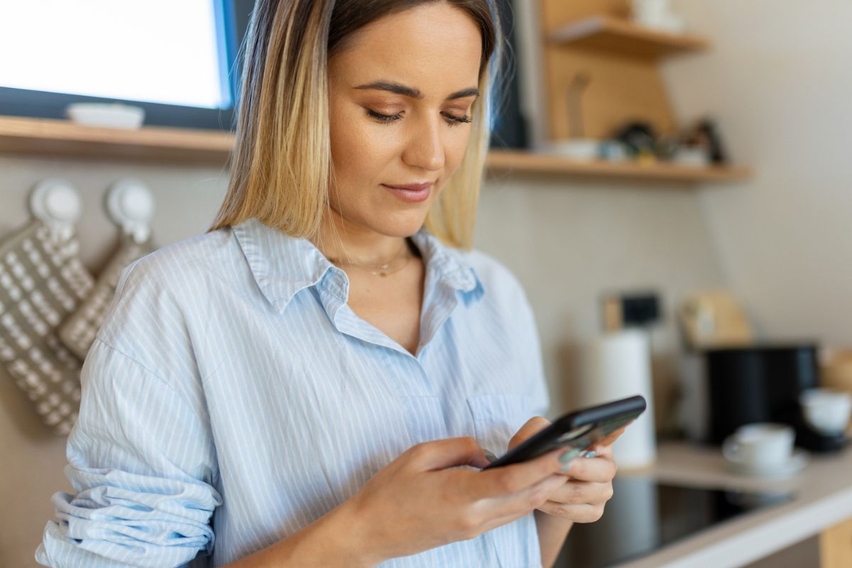 kobieta w kuchni z telefonem