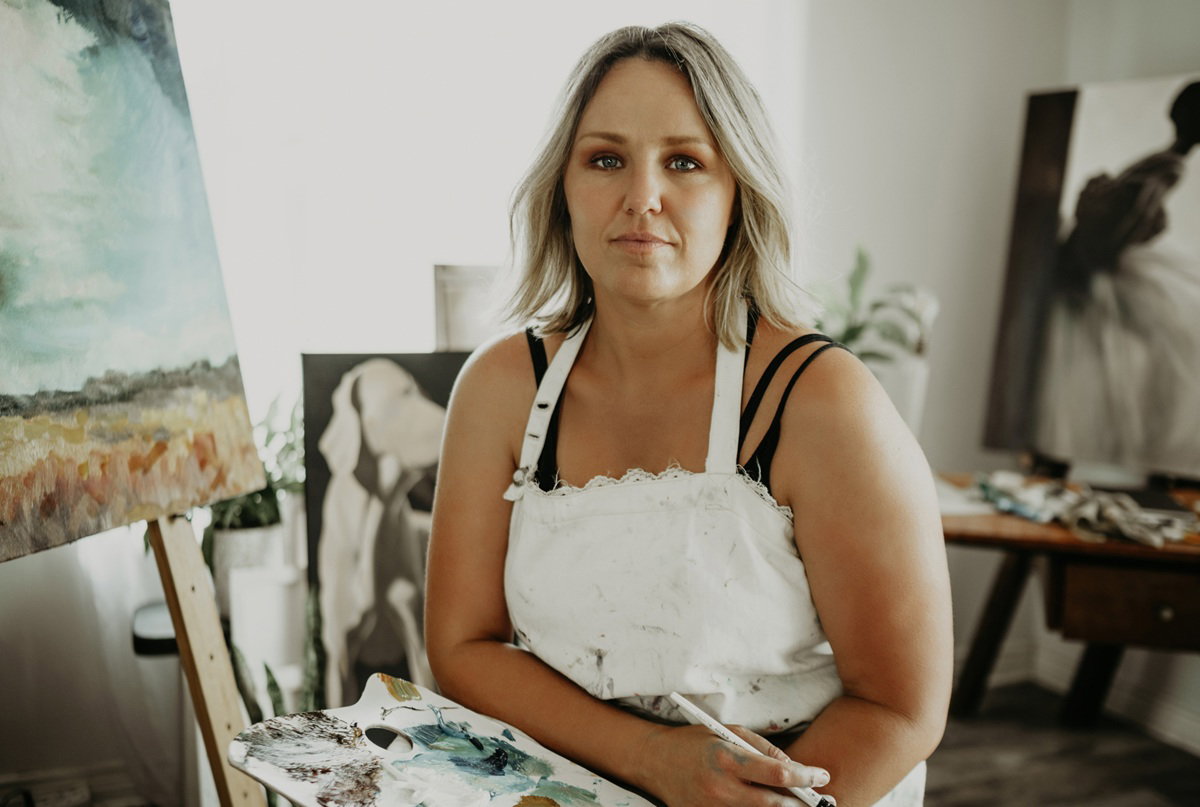 kobieta w wieku 35 plus blondynka siedzi przy sztaludze zamyślona