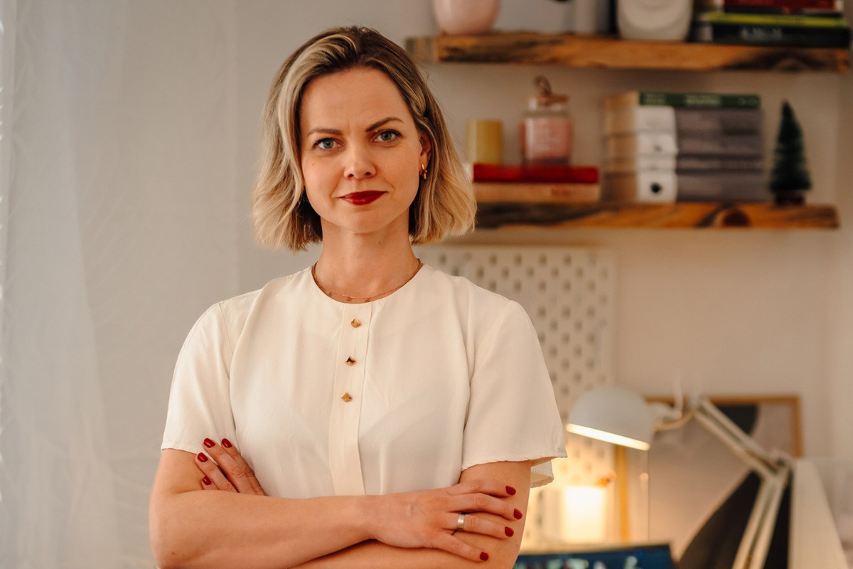 kobieta w wieku 30 plus blondynka stoi poważna na tle biurka