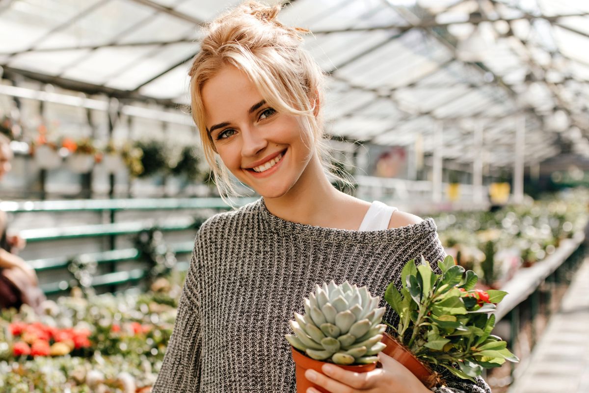 Uśmiechnięta kobieta z sadzonkami roślin
