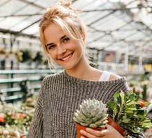 Uśmiechnięta kobieta z sadzonkami roślin