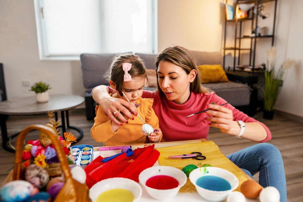 kobieta z dzieckiem maluje pisanki