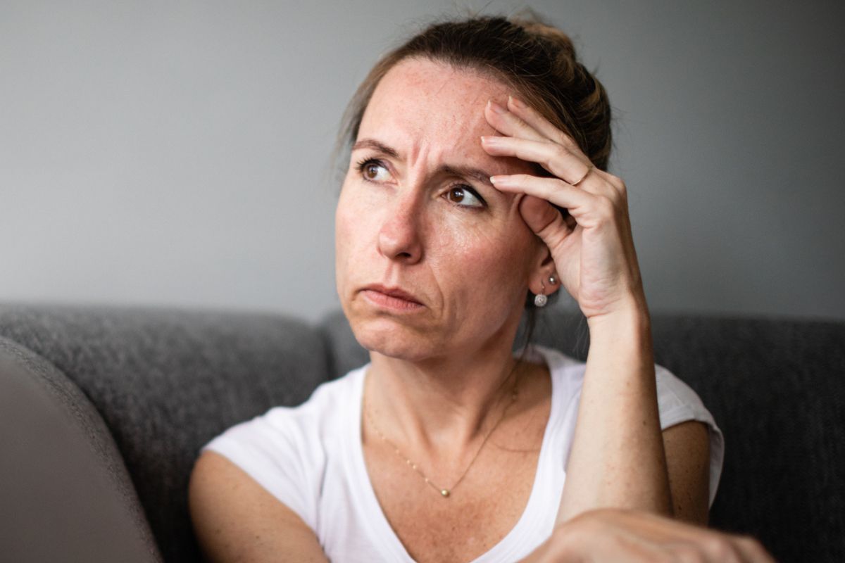 kobieta trzymająca się za czoło