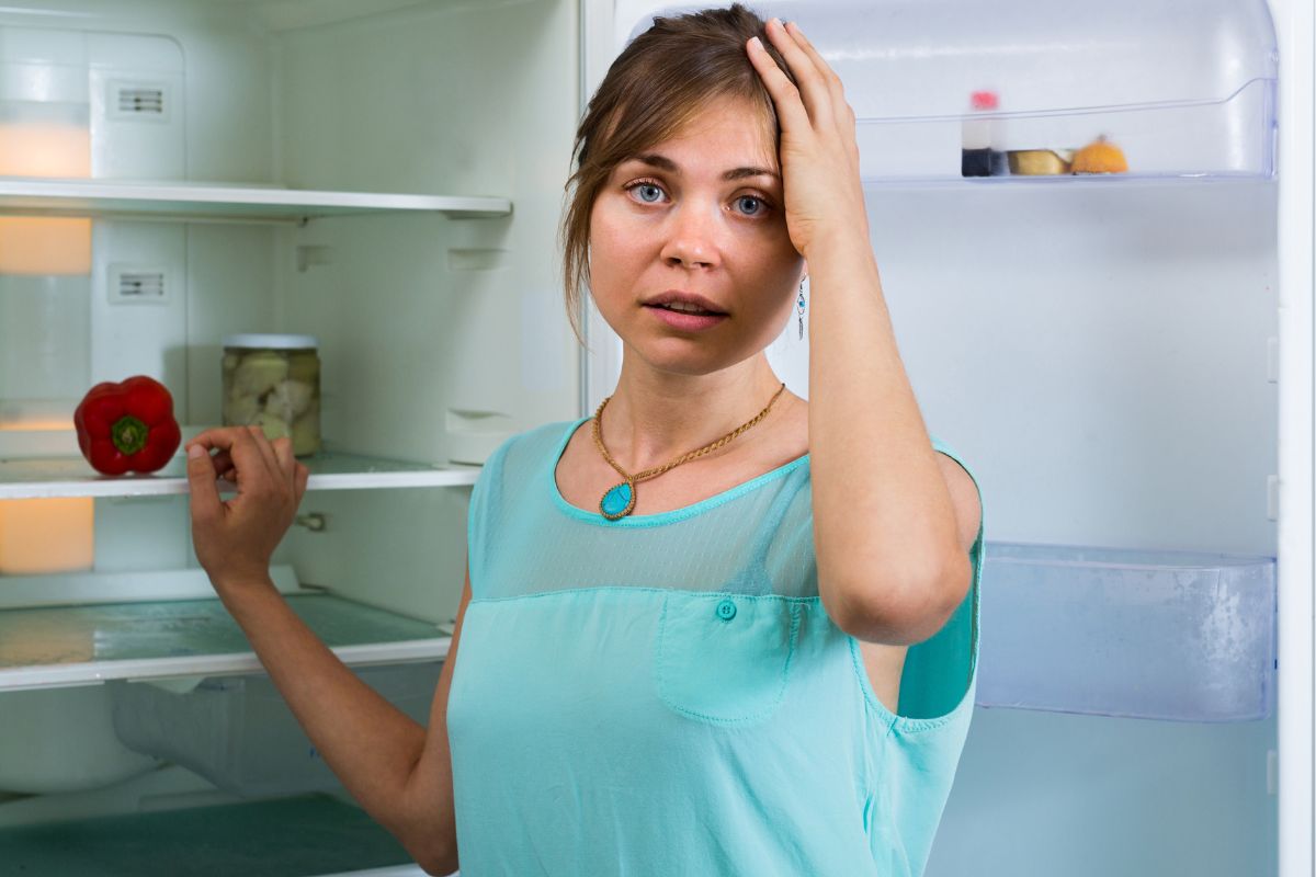 Załamana kobieta przy lodówce