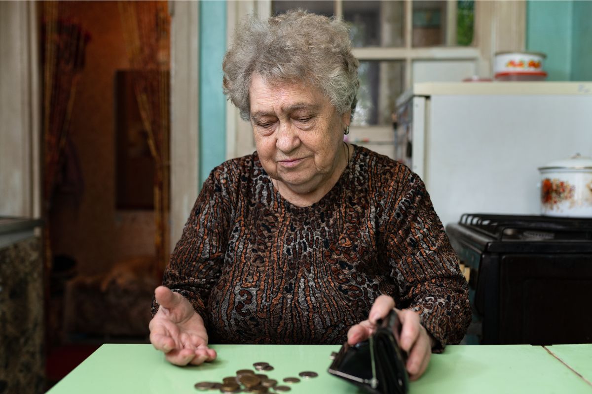Smutna starsza kobieta liczy pieniądze