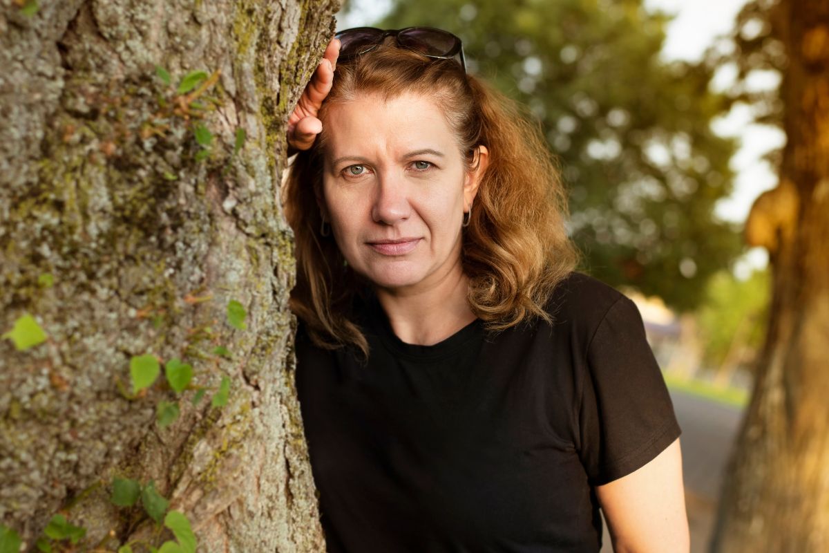 Zamyślona kobieta przy drzewie