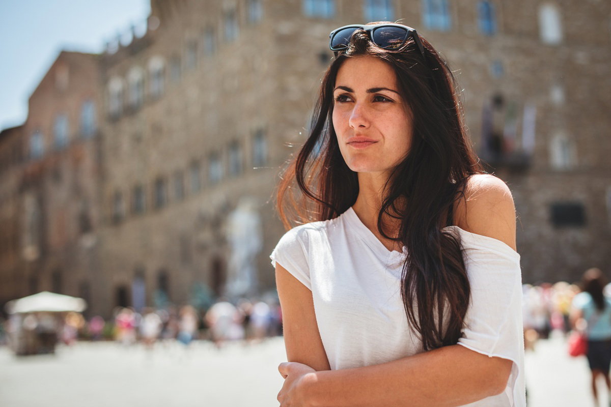 kobieta w wieku 30 plus z ciemnymi włosami stoi na tle miasta Florencja w Toskanii