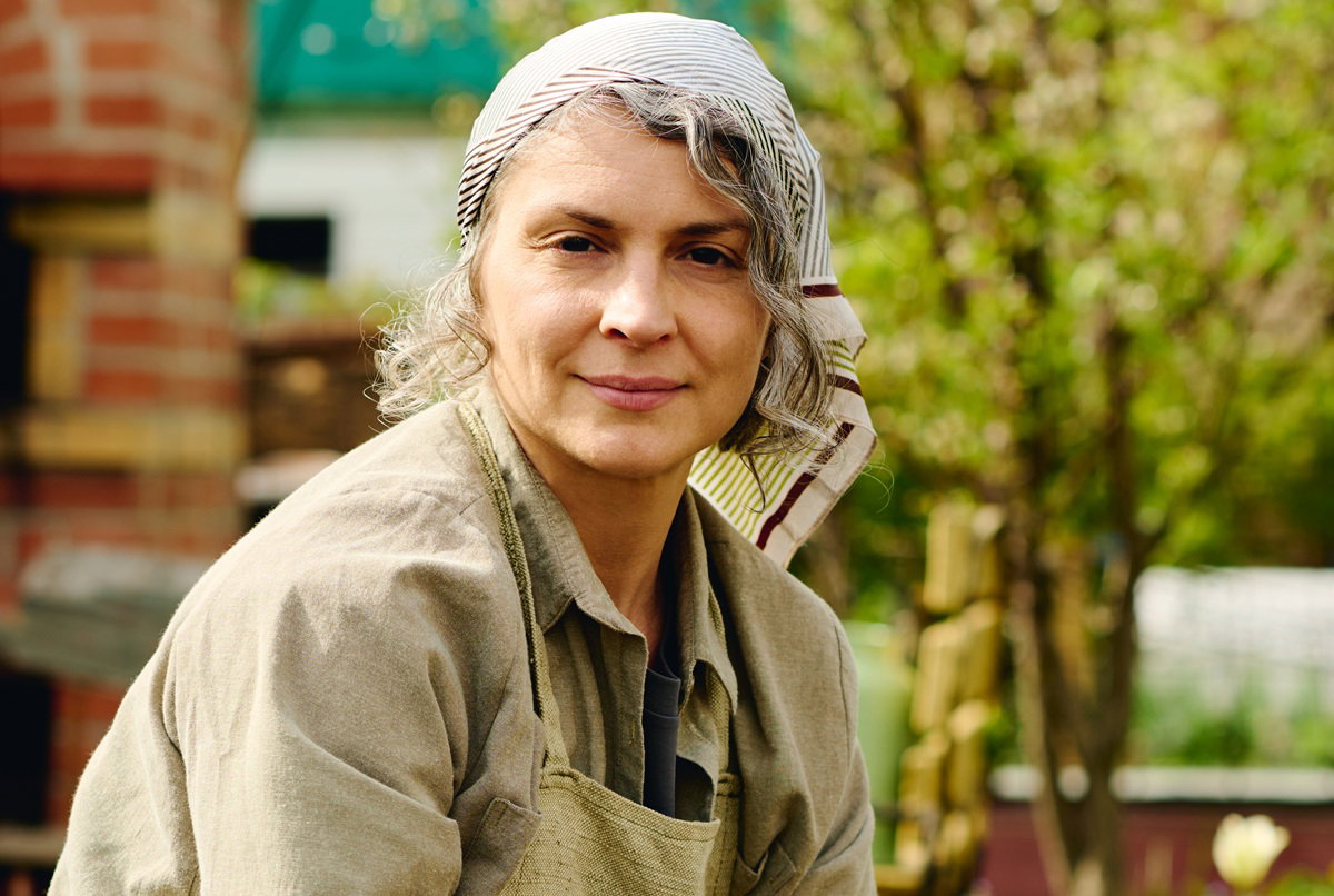 kobieta w wieku 40 plus w chustce na głowie porządkuje ogród