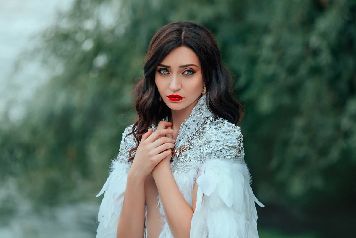 kobieta w wieku 25 plus w bogato zdobionym stroju panny młodej stoi na zewnątrz smutna i zamyślona