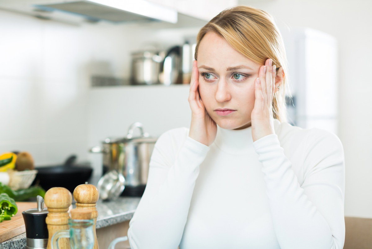 kobieta w wieku 25 plus blondynka siedzi w kuchni zmartwiona