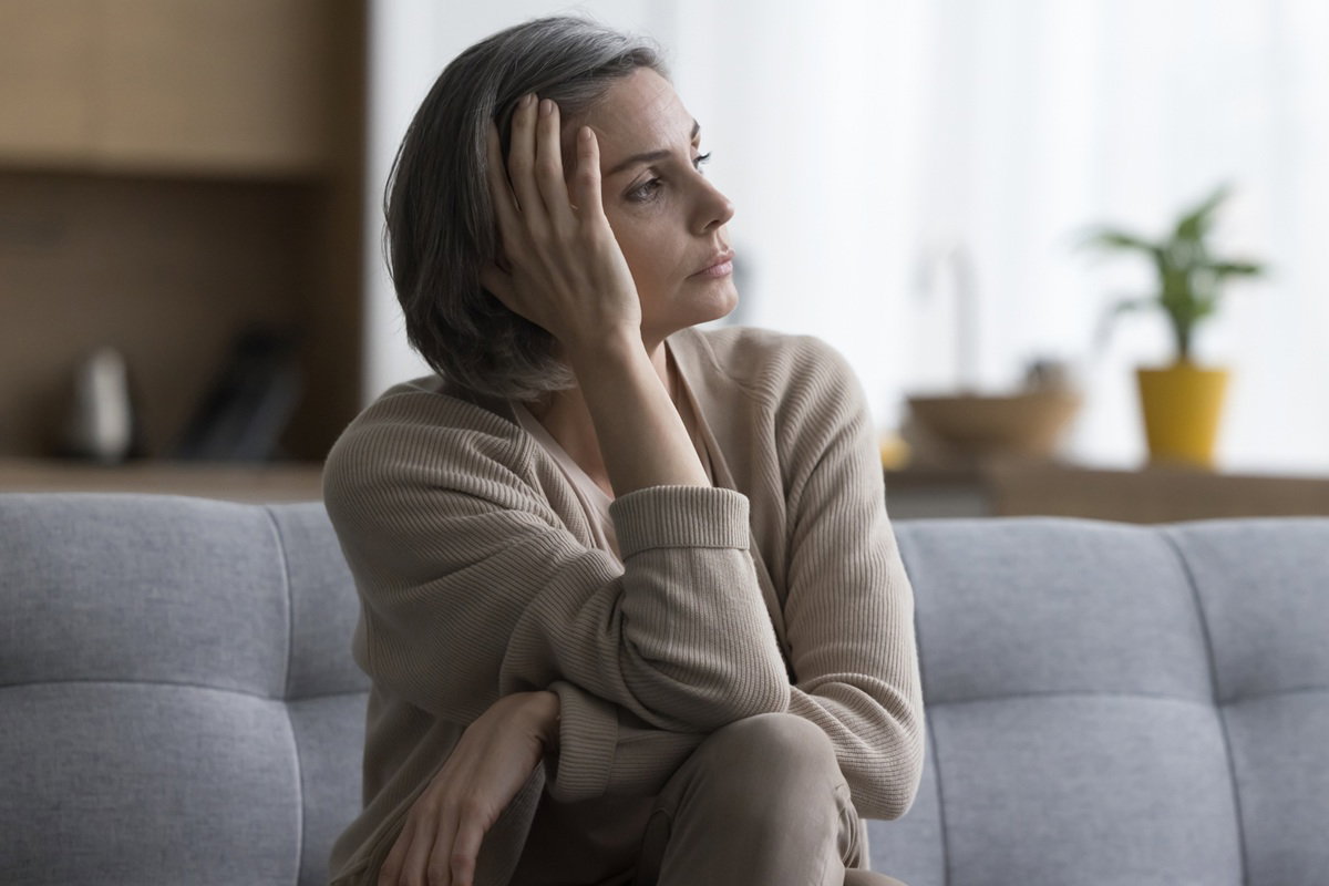 kobieta w wieku 40 plus siwe włosy siedzi na kanapie