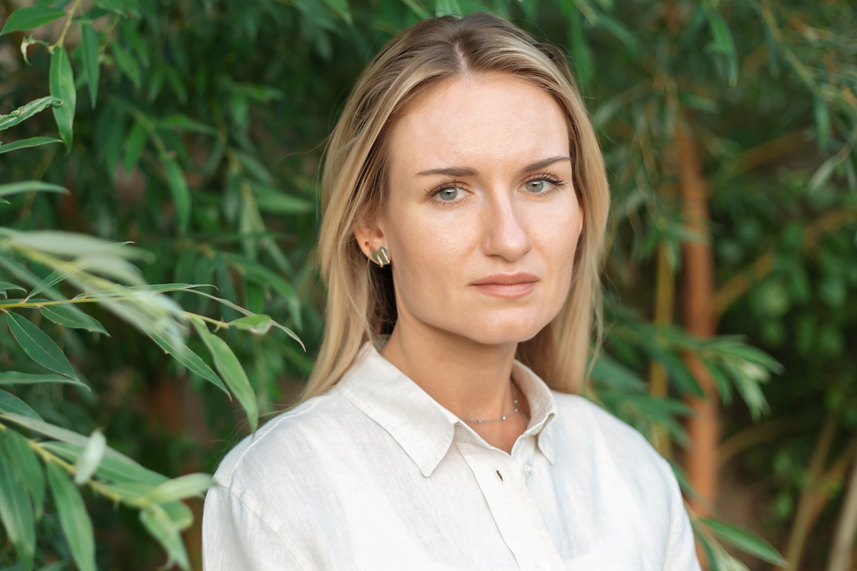 kobieta w wieku 30 plus blondynka stoi na tle wierzb smutna i zamyślona